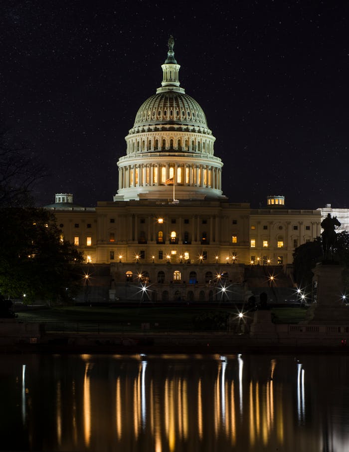 services-04 Night view of the iconic US Capitol Building in Washington, DC, beautifully illuminated and reflected in water.